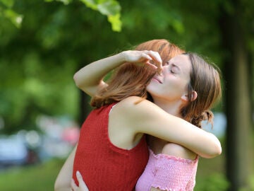 Dos amigas se abrazan y una se tapa la nariz al notar mal olor