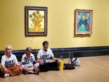 Tres activistas protestan después de lanzar sopa de tomate a 'Los Girasoles de 1888 y 1889 de Van Ggh, en la National Gallery de Londres, a 27 de septiembre del 2024