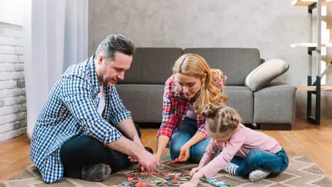 Familia jugando en la alfombra Familia jugando en la alfombra