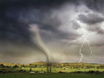 Montaje de un tornado y un relámpago sobre una aldea