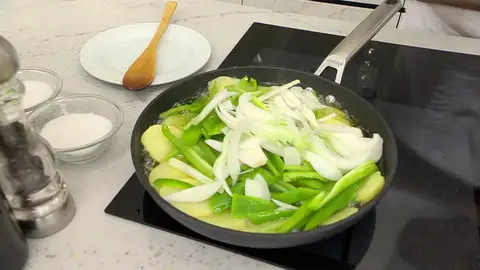 Introduce los pimientos y las cebolletas en la sartén Introduce los pimientos y las cebolletas en la sartén