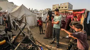 Niños ante los restos calcinados de unas tiendas en el campamento de Deir al Balah Niños ante los restos calcinados de unas tiendas en el campamento de Deir al Balah