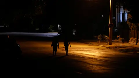 Fotografía de archivo de personas que caminan por una calle con poca iluminación en La Habana Fotografía de archivo de personas que caminan por una calle con poca iluminación en La Habana