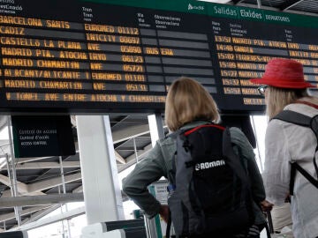 Pasajeros mirando los horarios de los trenes