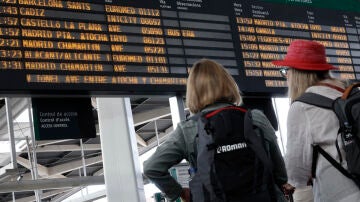 Pasajeros mirando los horarios de los trenes