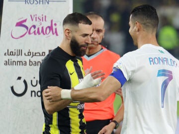 Cristiano Ronaldo y Karim Benzema se saludan antes de un partido en el Prince Abdullah Al Faisal Stadium