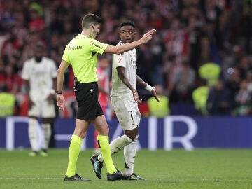 El árbitro Busquets Ferrer conversa con Vinícius en el derbi en el Metropolitano