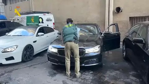 Un agente de Guardia Civil junto a uno de los vehículos de lujo robados Un agente de Guardia Civil junto a uno de los vehículos de lujo robados