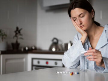 Una mujer con sueño se toma medicamentos