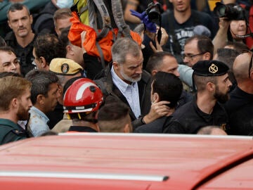 El rey Felipe habla con uno de los vecinos afectados durante su visita a Leitur este domingo. 