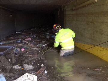 Un bombero trabajando en uno de los aparcamientos inundados