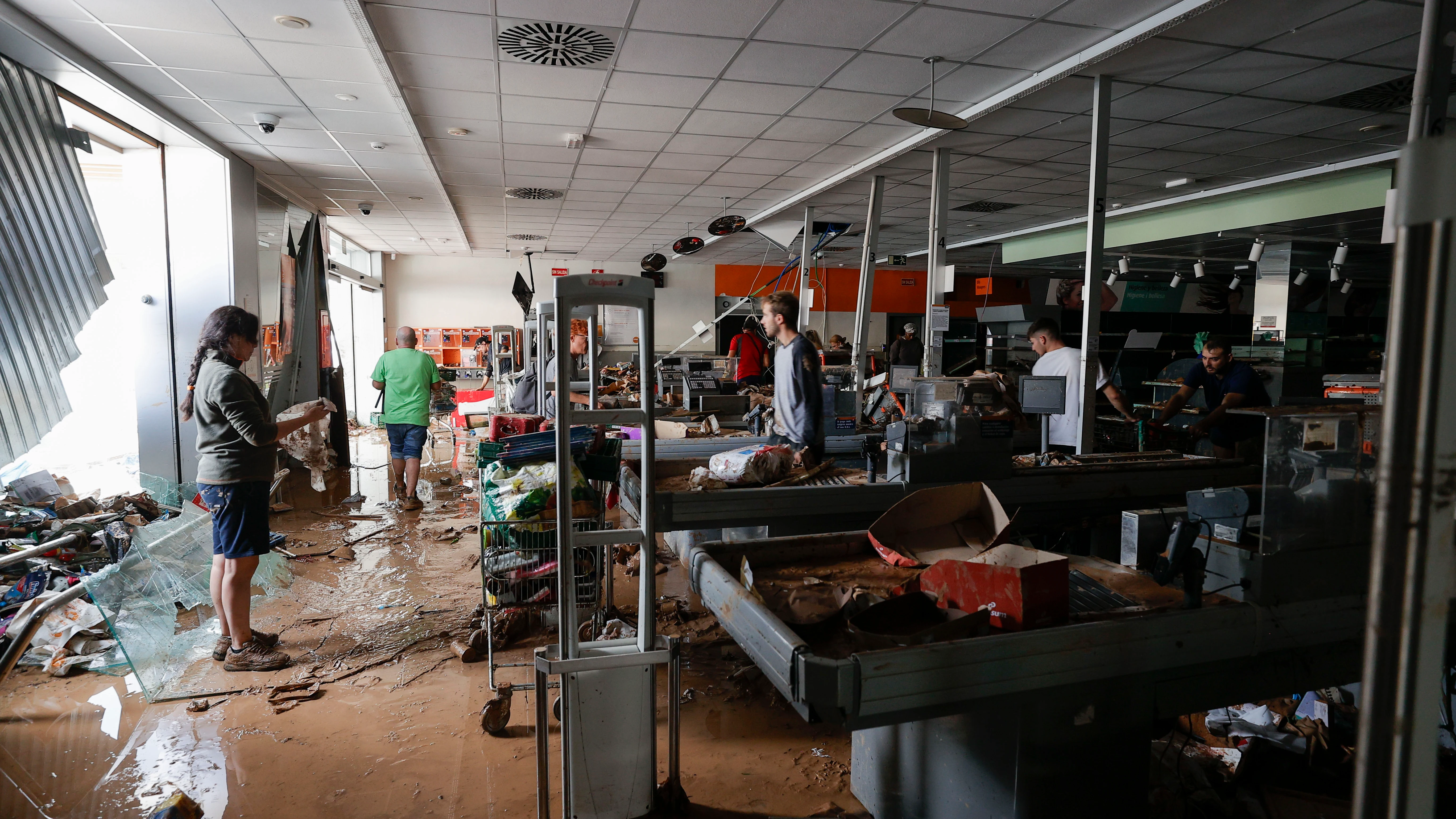 Varias personas intentan recoger alimentos de una tienda de Paiporta Varias personas intentan recoger alimentos de una tienda de Paiporta
