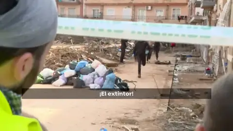 Un policía corre en búsqueda de un extintor Un policía corre en búsqueda de un extintor