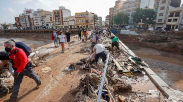 Decenas de voluntarios trabajan para despejar uno de los puentes de Paiporta