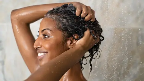 Una mujer aclarándose el pelo rizado Una mujer aclarándose el pelo rizado