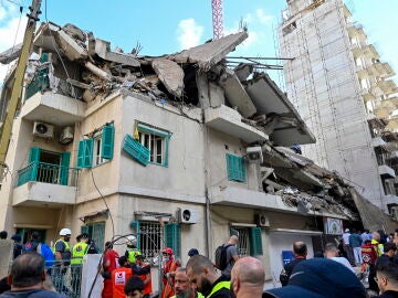 Rescatistas y personas se reúnen en el lugar del ataque aéreo israelí contra la sede del partido Baath en el barrio de Ras Al Naba'a, en Beirut 