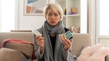 Una mujer con diversos medicamentos en la mano 