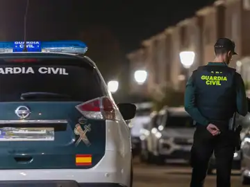 Un agente de la Guardia Civil con su coche Un agente de la Guardia Civil con su coche