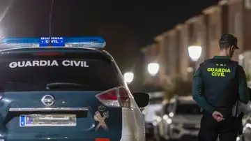 Un agente de la Guardia Civil con su coche Un agente de la Guardia Civil con su coche