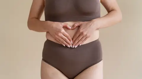 Una mujer se toca el vientre Una mujer se toca el vientre