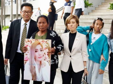 La madre de una de las víctimas de 'Am Cyanide' sostiene la foto de su hija a las puertas del Tribunal Penal de Bangkok