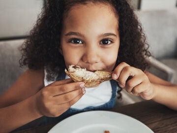 Una niña come pescado