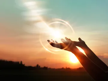 Unas manos alzadas para atraer la energía del sol Unas manos alzadas para atraer la energía del sol