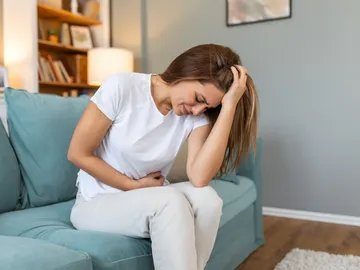Una mujer con dolor en la zona abdominal Una mujer con dolor en la zona abdominal