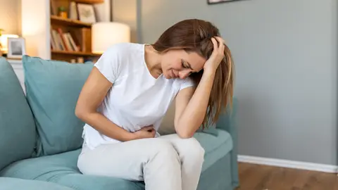 Una mujer con dolor en la zona abdominal Una mujer con dolor en la zona abdominal