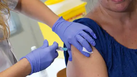 Una mujer recibe una vacuna Una mujer recibe la vacuna antigripal