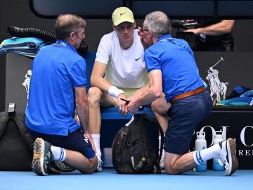 Jannik Sinner es atendido por el médico del Open de Australia durante su duelo ante Rune