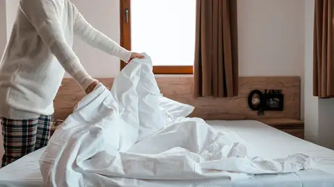 Mujer colocando la funda del edredón Mujer colocando la funda del edredón