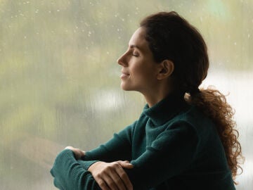Una mujer relajada con lluvia de fondo