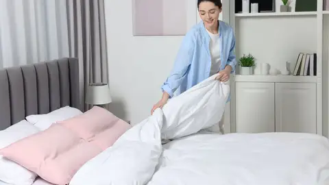 Mujer haciendo la cama Mujer haciendo la cama