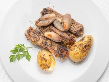 Costillas de cerdo guisado-asado con patatas y chalotas