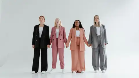 Mujeres cogidas de la mano con trajes de distintos estilos Mujeres cogidas de la mano con trajes de distintos estilos