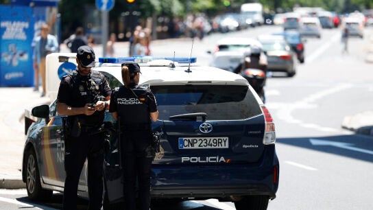 Imagen de archivo de una pareja de agentes junto a un coche de la Polic&iacute;a Nacional.