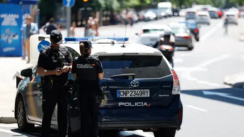 Imagen de archivo de una pareja de agentes junto a un coche de la Policía Nacional. Imagen de archivo de una pareja de agentes junto a un coche de la Policía Nacional.