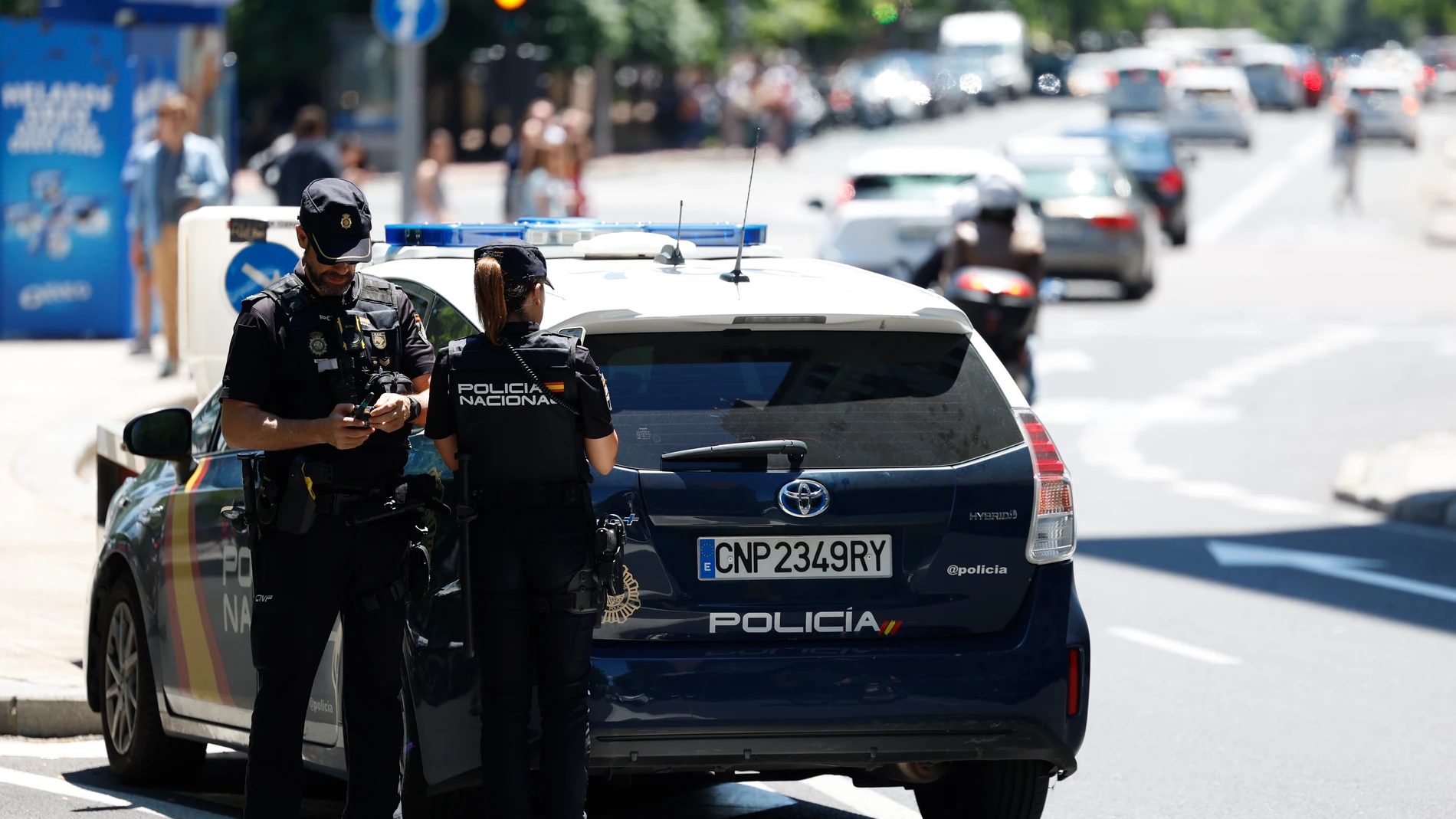 Imagen de archivo de una pareja de agentes junto a un coche de la Policía Nacional. Imagen de archivo de una pareja de agentes junto a un coche de la Policía Nacional.