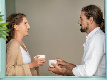 Una pareja dialoga tomándose un café Una pareja dialoga tomándose un café
