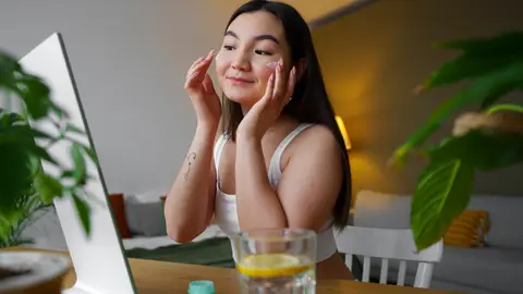 Mujer aplicándose un cosmético Mujer aplicándose un cosmético