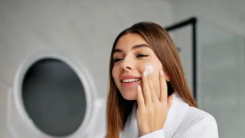 Mujer aplicándose un cosmético Mujer aplicándose un cosmético