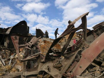 Unos residentes locales inspeccionan los daños tras un ataque nocturno con bomba en Zaporiyia