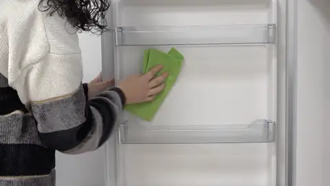 Una persona limpiando la nevera Una persona limpiando la nevera