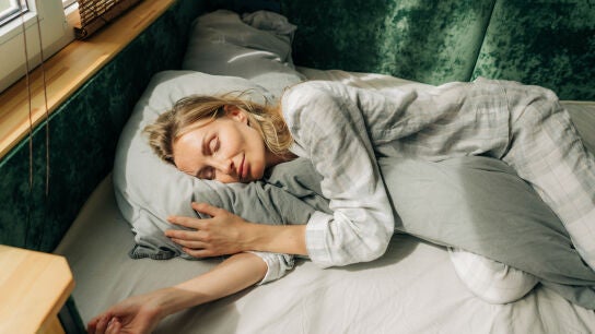 Una mujer durmiendo abrazada a una almohada