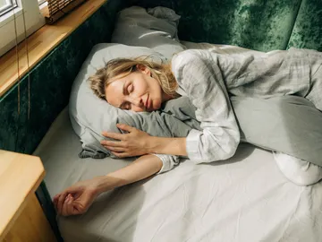 Una mujer durmiendo abrazada a una almohada Una mujer durmiendo abrazada a una almohada