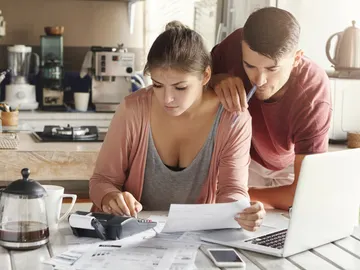 Una pareja hace cuentas y gestiona sus finanzas Una pareja hace cuentas y gestiona sus finanzas
