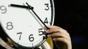 Una persona cambiando la hora de un reloj