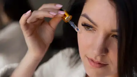 Mujer poniéndose sérum en la cara Mujer poniéndose sérum en la cara