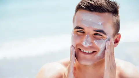 Hombre poniéndose protección solar Hombre poniéndose protección solar